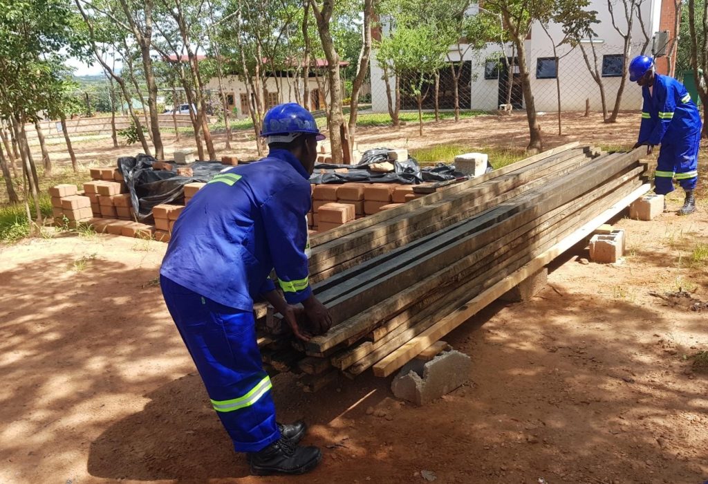 Trainees treating the roof timbers of the student toilet block at the Centre for Excellence